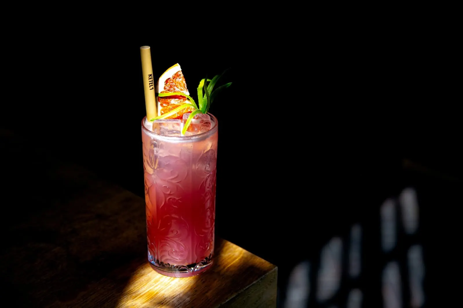 Roze cocktail met gedroogde grapefruit in een bewerkt glas