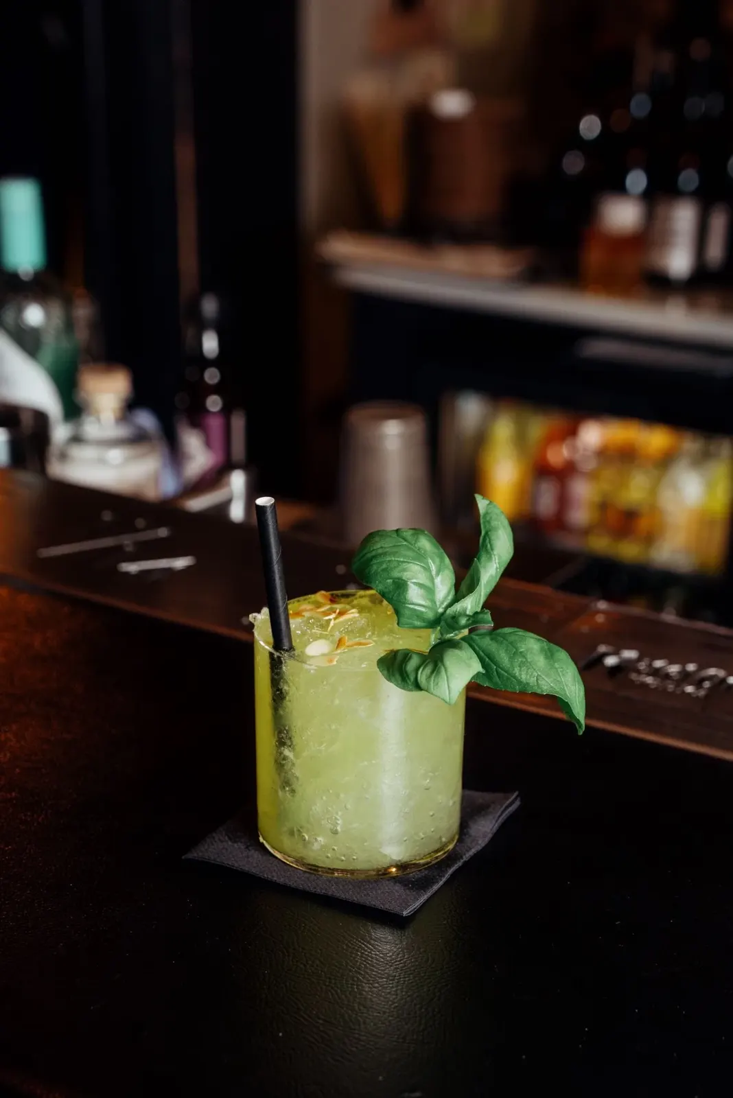 Groene cocktail met ijs en basilicum op de bar van 1714