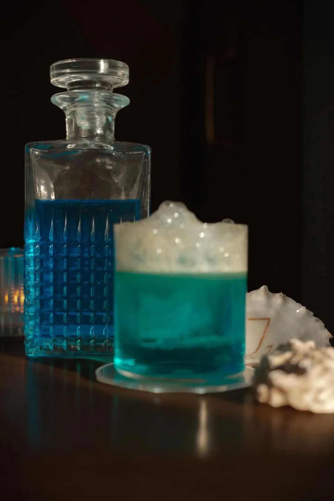 The Wave, blauwe cocktail met schuim naast een karaf